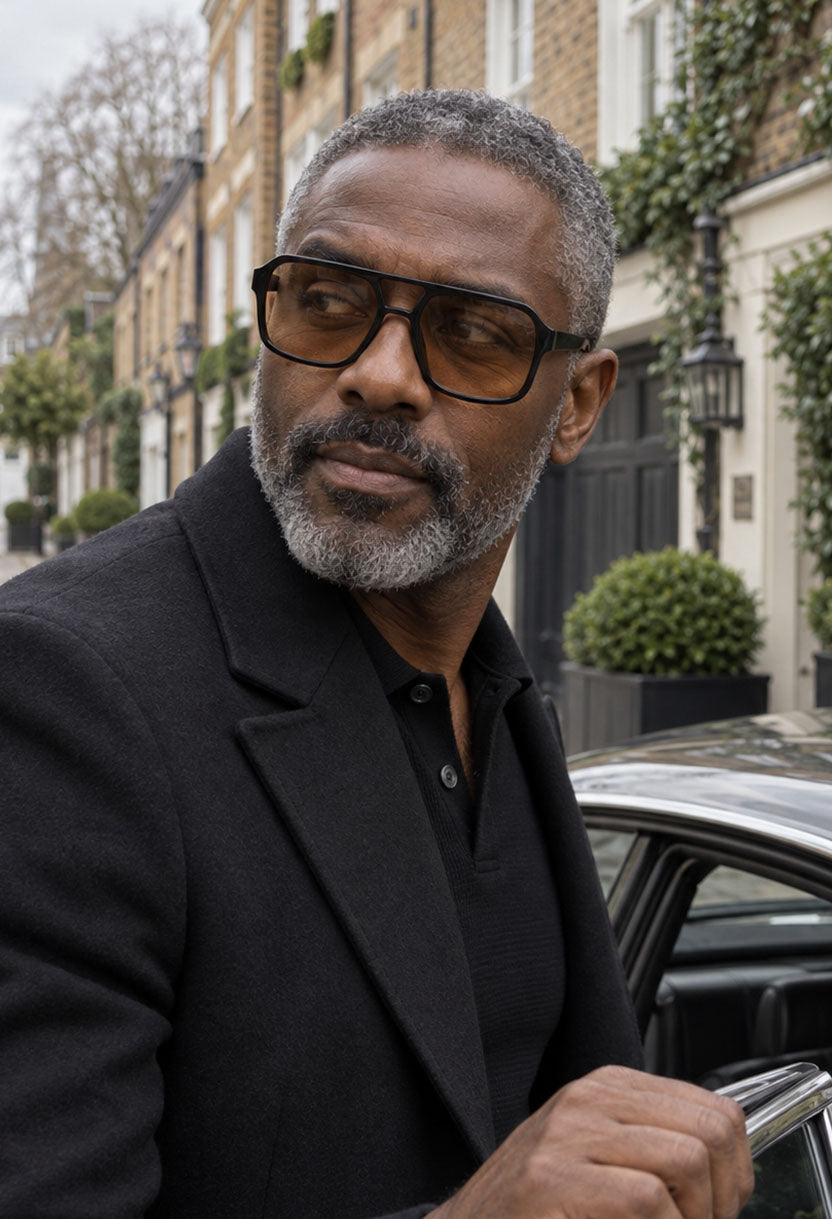 Man with grey hair and a grey beard wearing NEW STATEMENT AZTEC sunglasses on a city street #color_brown
